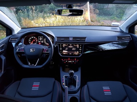 Salpicadero de un SEAT Ibiza 6F con cuadro analógico, pantalla central elevada y asientos con costuras rojas
