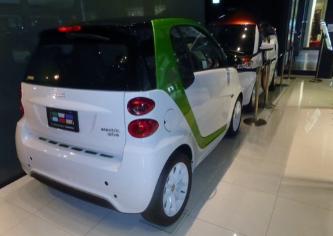 Smart Fortwo Electric Drive blanco y verde, biplaza urbano, en una exposición