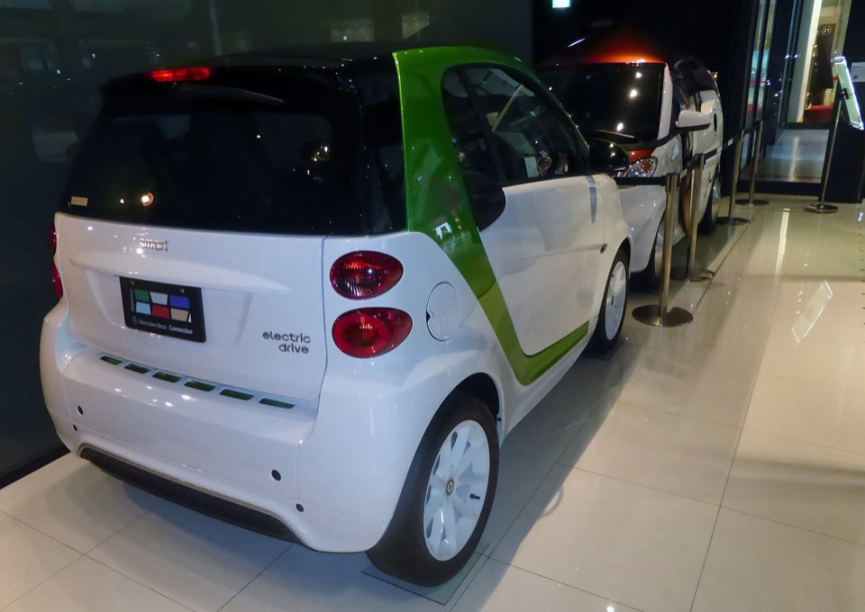 Smart Fortwo Electric Drive blanco y verde, biplaza urbano, en una exposición