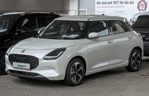 Suzuki Swift híbrido gris en el exterior de un concesionario