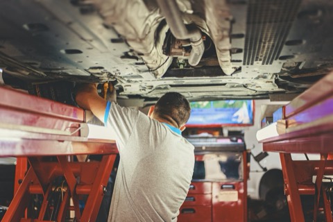 Interior de un taller con un coche sobre el elevador