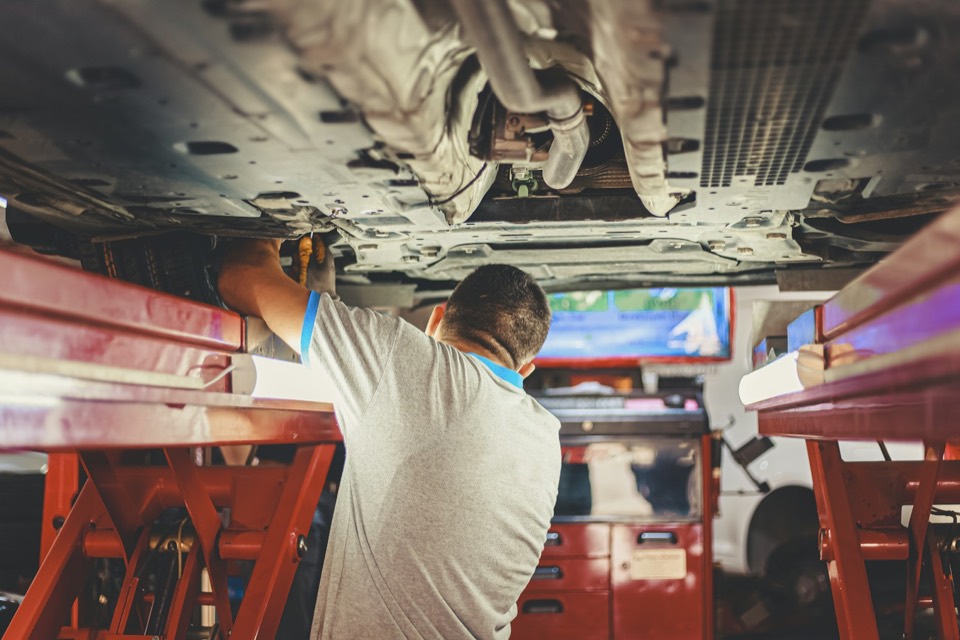 Interior de un taller con un coche sobre el elevador