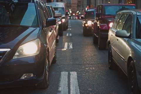 Tráfico denso en una avenida urbana al atardecer