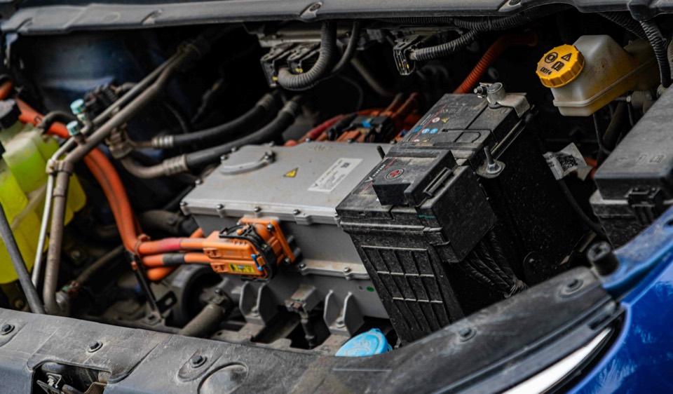 Vano motor de un coche eléctrico con el cableado de alta tensión naranja a la vista