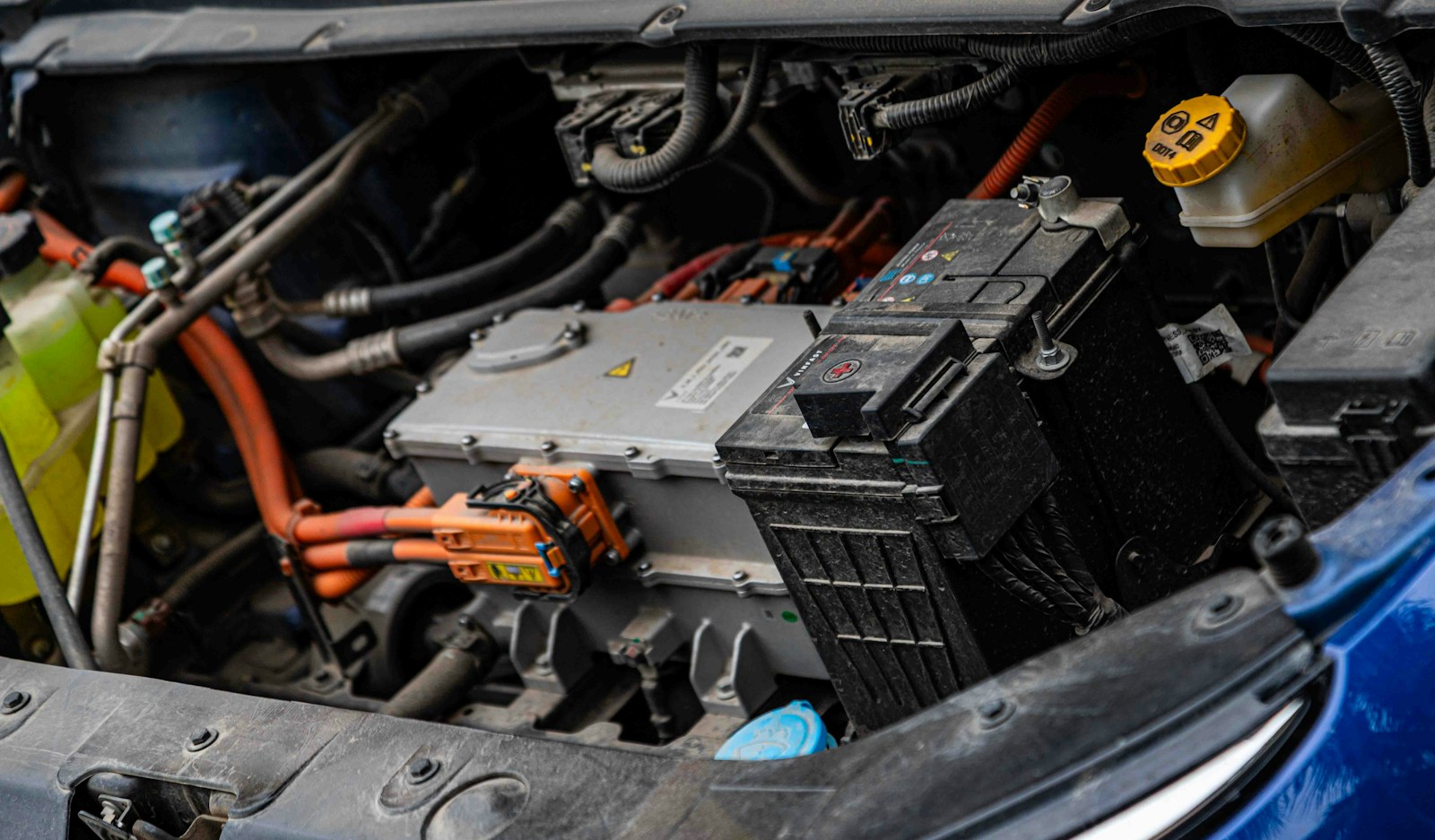 Vano motor de un coche eléctrico con el cableado de alta tensión naranja a la vista