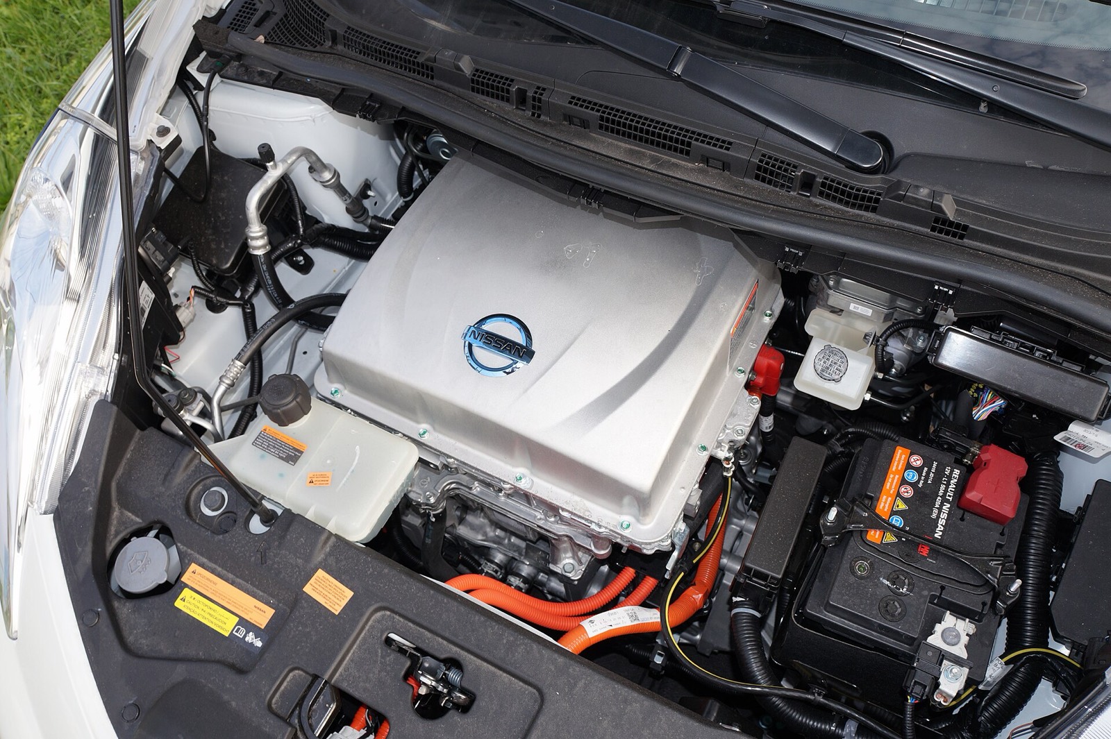 Vano motor abierto de un Nissan Leaf eléctrico: la unidad de tracción eléctrica y, a su derecha, la batería auxiliar de 12 voltios